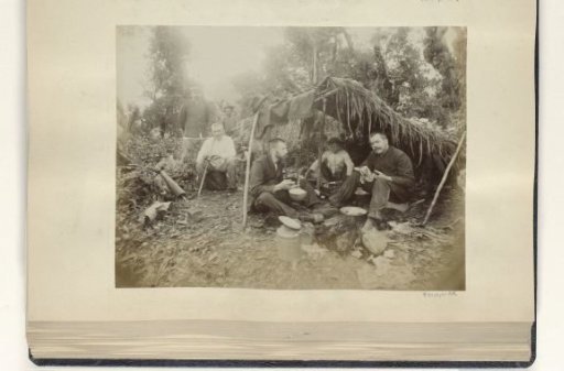 Presumably Dutch people with Indonesian servants by a hut in the Dutch East Indies