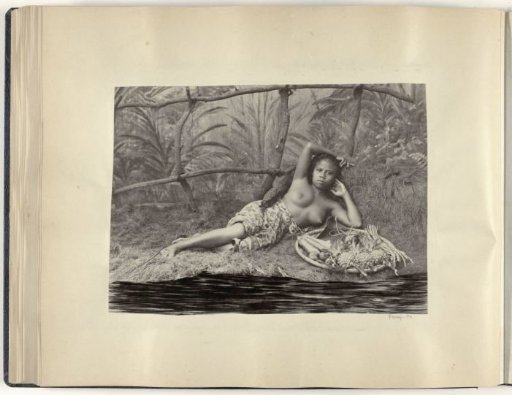 Portrait of a young half-nude Indonesian woman, lying with a fruit basket in a setting