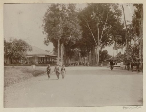 Street scene in the Dutch East Indies with children, porters and passers-by