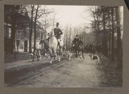 Equestrian scene at the Royal Woodlands of Het Loo: riders with a pack of hounds on a country road