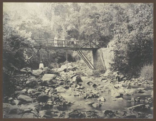 Wooden bridge over a stream with Indonesian people and (presumably) a Dutchman