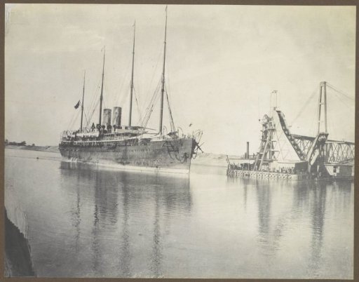 Ship sailing through the Suez Canal near a dredger