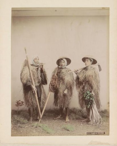 Portrait of three Japanese farmers with straw clothing and tools, one smoking