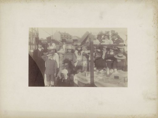Group portrait of women, men and children at a table, presumably in Sydney