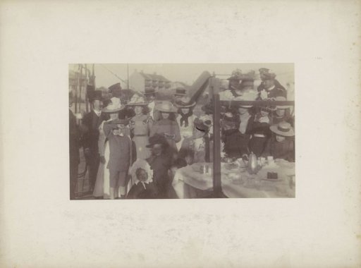 Group portrait of women, men and children at a table, presumably in Sydney