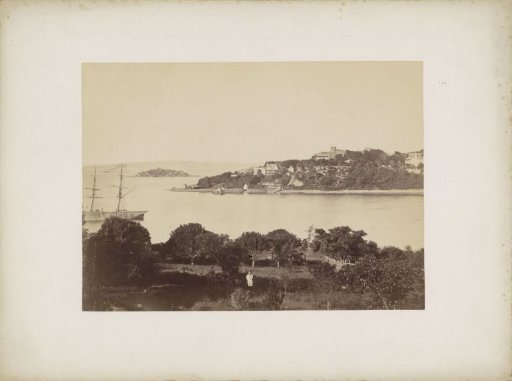 View of the harbour of (probably) Sydney with a boy in an orchard in the foreground