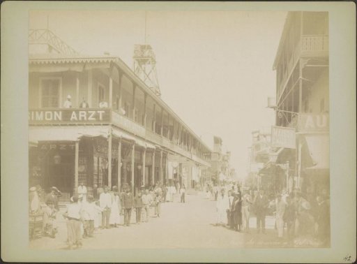 Rue du commerce in Port Said with shops including that of cigarette manufacturer Simon Arzt