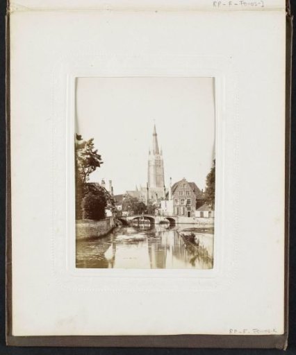 View of the city canal, the bridge of the Beguinage, houses and the Church of Our Lady in Bruges