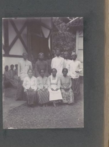 Group portrait of men and women in front of a building, probably on the grounds of a hospital in the Dutch East Indies