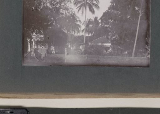 Passersby and an ox cart on a road, probably on the grounds of a hospital in the Dutch East Indies