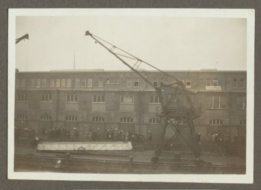 Waving people, a crane, and a rope on a quay