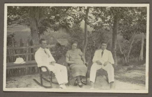 Two men in tropical dress and a woman sitting in rocking chairs