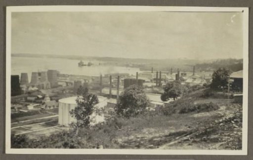 Harbour with ships, chimneys and storage tanks