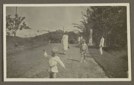 Woman with children and Indians on an avenue