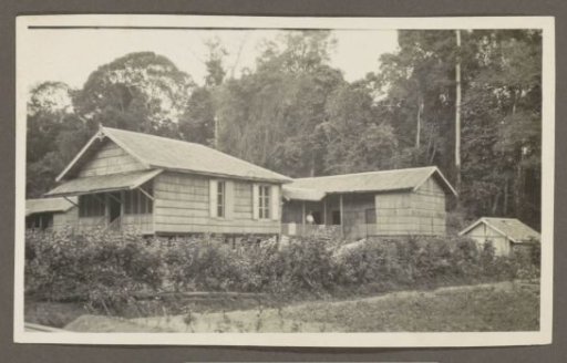 Two wooden houses with verandas and an outbuilding