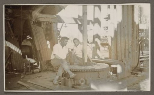 Two men sitting in a drilling tower