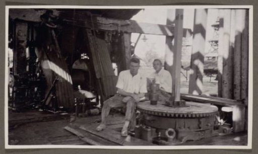 Two men sitting in a drilling tower