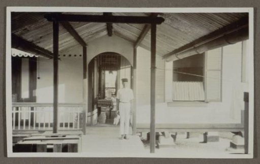 Indian man standing before a doorway in a covered space