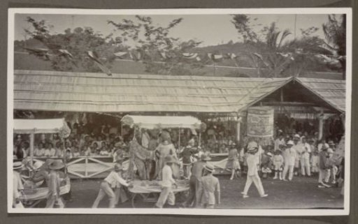 Parade with pageant wagons and participants before a tribune
