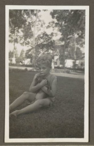 Seated boy with a dog in his arms