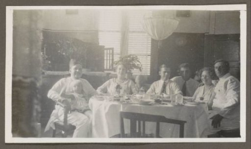 Men, women and children around a set table