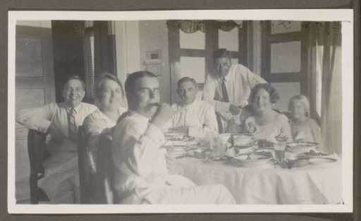 Men, women and children around a set table