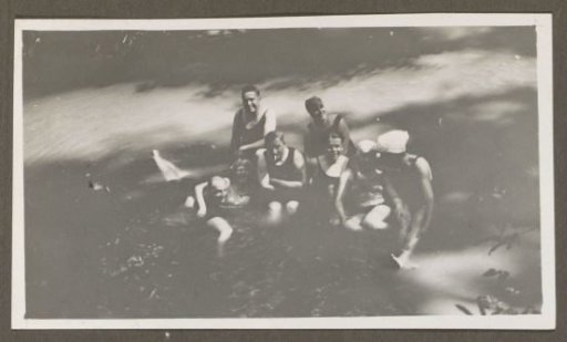 Group of men and women posing in shallow water