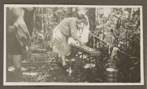 Woman pouring tea at a swimming party in a forest