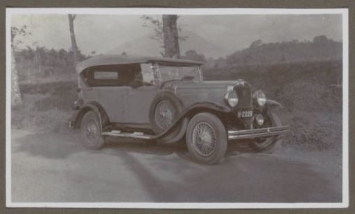 Man seated in an automobile (cabriolet) with a fabric hood