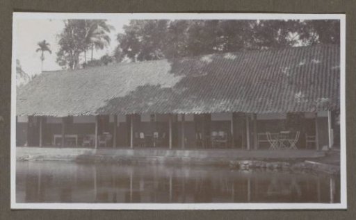 Building with covered seating by water, possibly a hospitality establishment