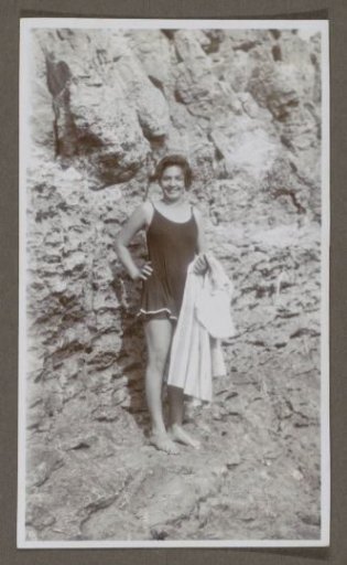 Woman in swimwear posing in front of a rock wall