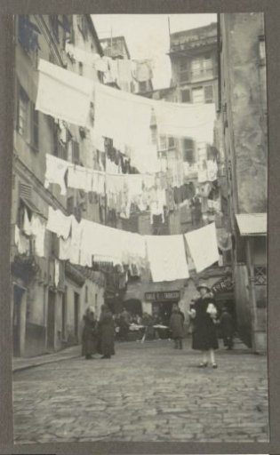 Woman posing in a street with drying laundry