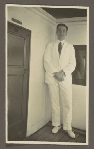 Man posing in a white costume on board a ship