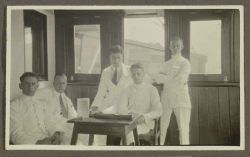 Five men in tropical dress sitting around a table