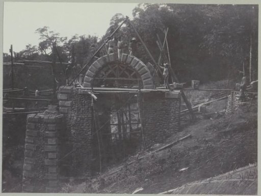Placement of the keystone on an arch at an abutment on the western bank of the Kali Brantas south of Malang (Photo XVII)