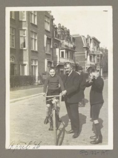 Man with (presumably) Hans and Georges Bergsma by a bicycle on the street in the Netherlands