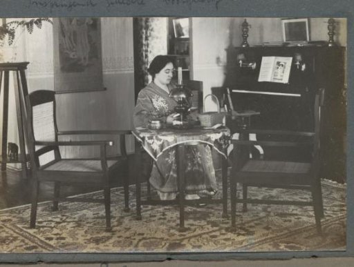 Gerda Bergsma in long dress sitting at a table in a residence on Sumatra