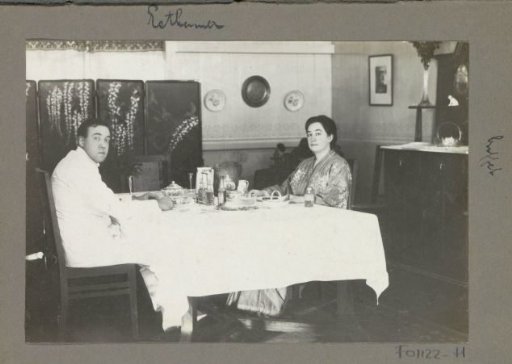 Eiso Bergsma in tropical clothing and Gerda Bergsma in long dress sitting at dining table in a residence on Sumatra