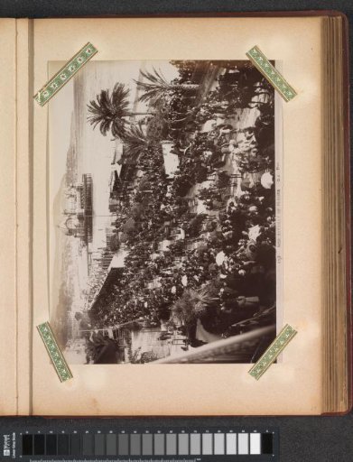 Parade with spectators during the Bataille de Fleurs in Nice, with a pier and buildings in the background