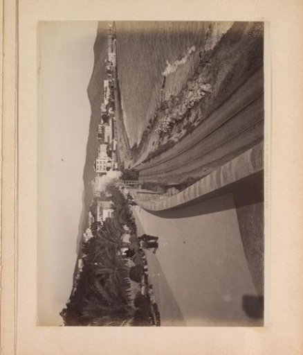 View of the boulevard and a railway with steam locomotive along the coast near San Remo