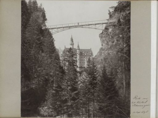 View of Neuschwanstein Castle in Bavaria with forests, bridge, and walker