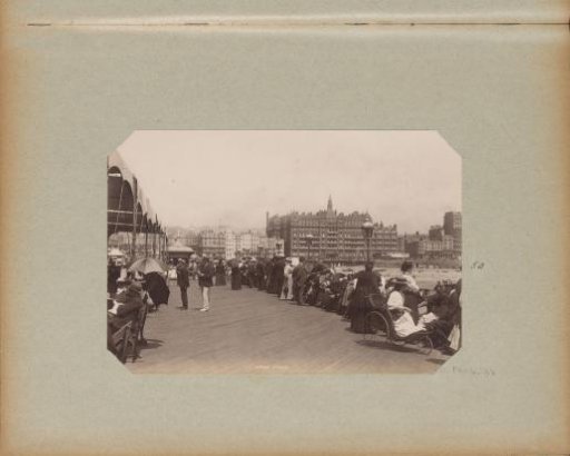People on the Brighton pier with the Hotel Metropole in the background