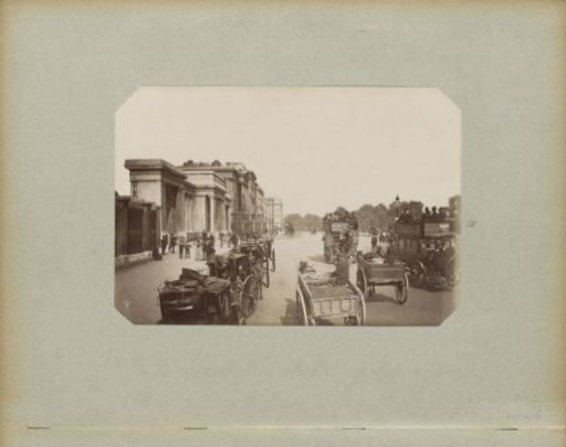 Hyde Park Corner in London with horse-drawn carriages, carts, and a horse tram