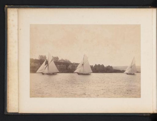 Sailing ships Yvonne, Doris and Darthula on the water with buildings in the background