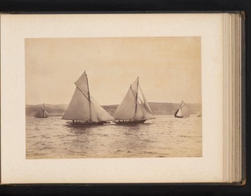 Various sailing ships, including the Woodcock and Yvonne, afloat with a hilly landscape in the background
