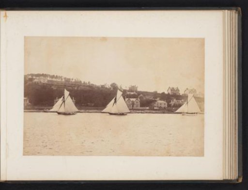 Three sailing ships, including the Coila, launched with a landscape with buildings in the background