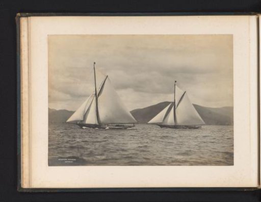 Sailing ships Meteor and Iverna afloat with a hilly landscape in the background