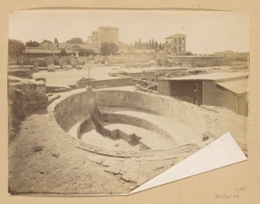 View of an excavation with a visitor near the remains of a bath, probably in Rome