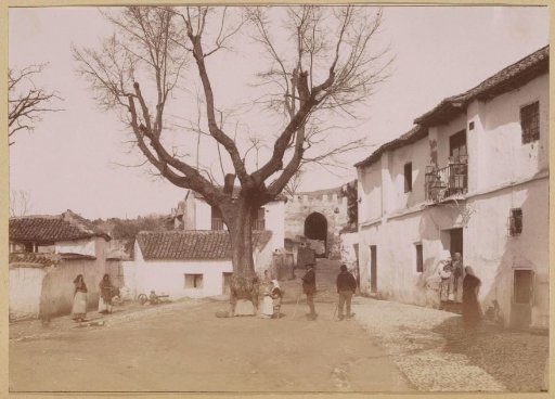 View of a square in Albaicín, Granada, with the Puerta de Elvira in the background