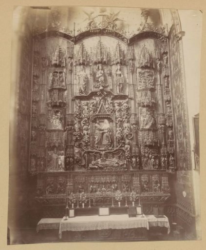 Carved wooden altarpiece, possibly in a Spanish church, on the right a badge of the Order of the Garter